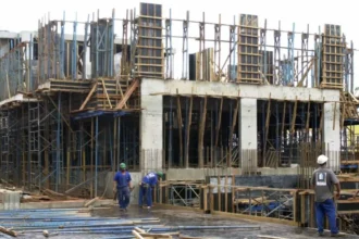 Imagem ilustrativa mostra trabalhadores durante construção de edifício